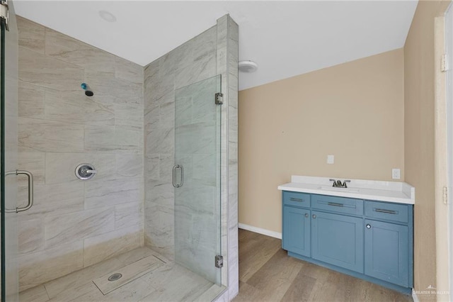 209 E 11th St, San Juan, TX 78589 - bathroom with wood finished floors, a stall shower, vanity, and baseboards
