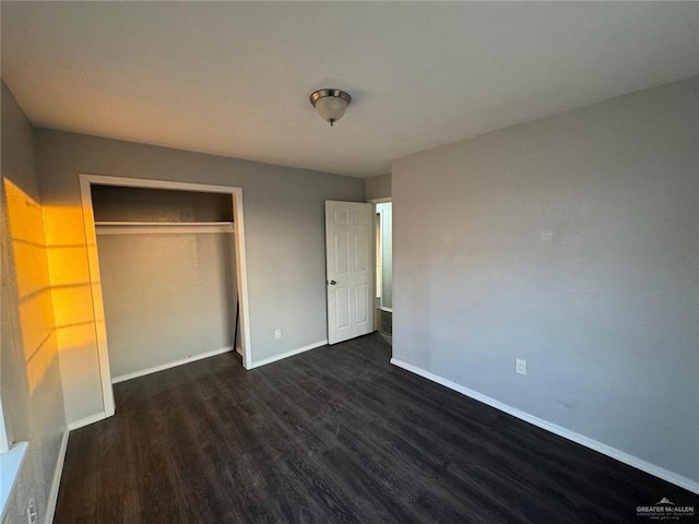 unfurnished bedroom featuring dark hardwood / wood-style floors and a closet