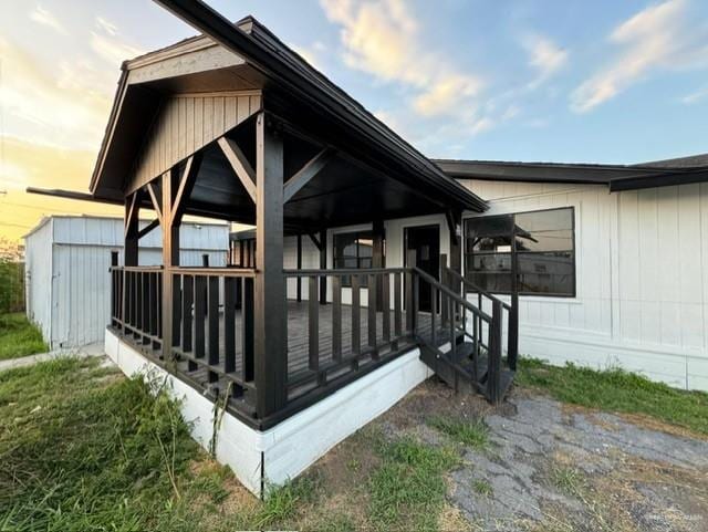 back house at dusk with a porch