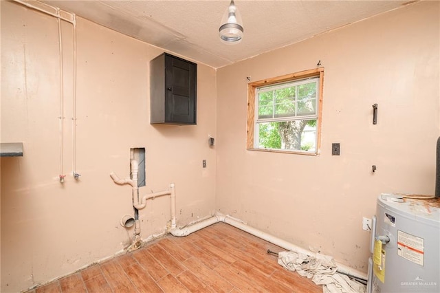 408 E Ebony St, La Feria, TX 78559 - laundry area with light wood-style flooring, water heater, and electric dryer hookup