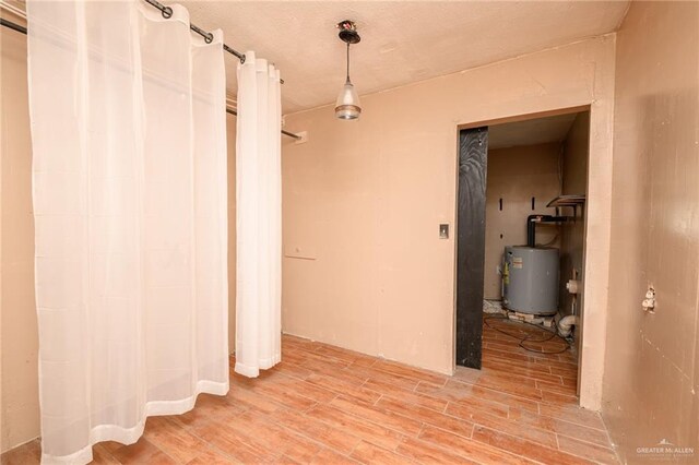 408 E Ebony St, La Feria, TX 78559 - hallway featuring gas water heater and light wood-type flooring