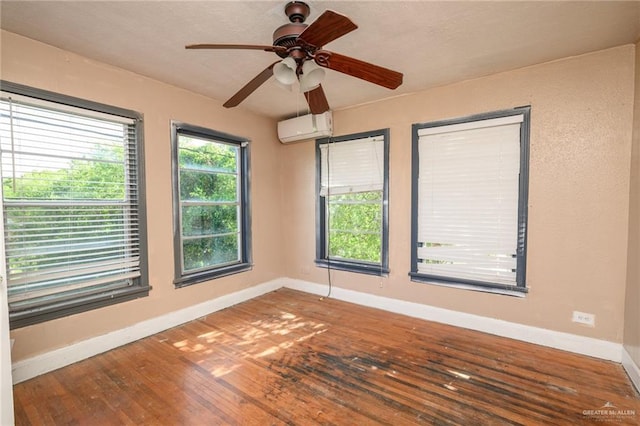 408 E Ebony St, La Feria, TX 78559 - unfurnished room with a wall unit AC, hardwood / wood-style flooring, and a ceiling fan