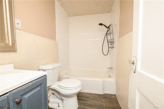 408 E Ebony St, La Feria, TX 78559 - full bath featuring tile walls, wood finished floors, vanity, bathtub / shower combination, and wainscoting