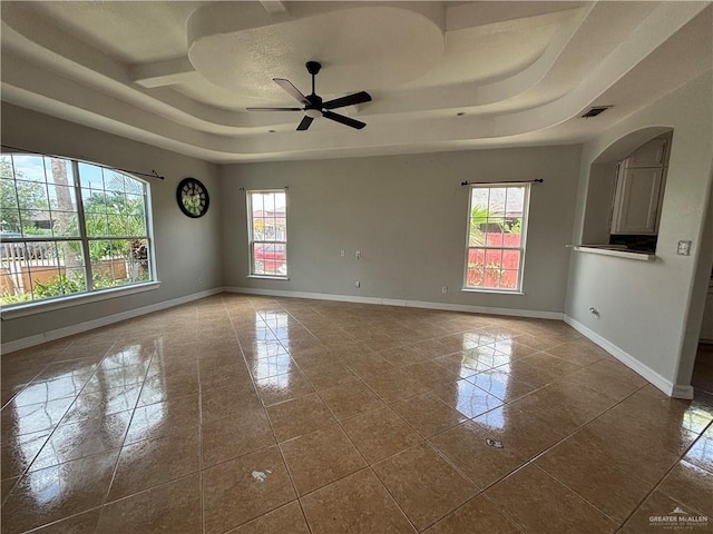 1708 Ivory St, Edinburg, TX 78541 - unfurnished room with plenty of natural light, a raised ceiling, baseboards, and dark tile patterned flooring