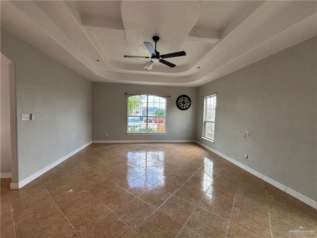 1708 Ivory St, Edinburg, TX 78541 - empty room with a ceiling fan, tile patterned floors, a tray ceiling, and baseboards