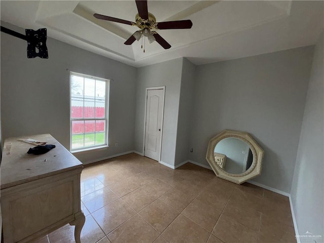 1708 Ivory St, Edinburg, TX 78541 - unfurnished bedroom with light tile patterned flooring, baseboards, a raised ceiling, and a ceiling fan