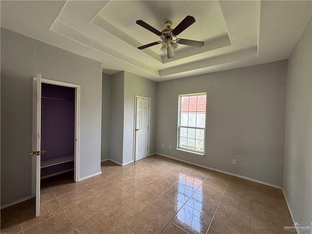 1708 Ivory St, Edinburg, TX 78541 - unfurnished bedroom featuring a raised ceiling, baseboards, a ceiling fan, and tile patterned flooring