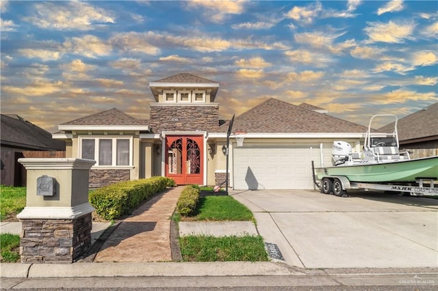view of front of home featuring stone siding, french doors, concrete driveway, stucco siding, and an attached garage