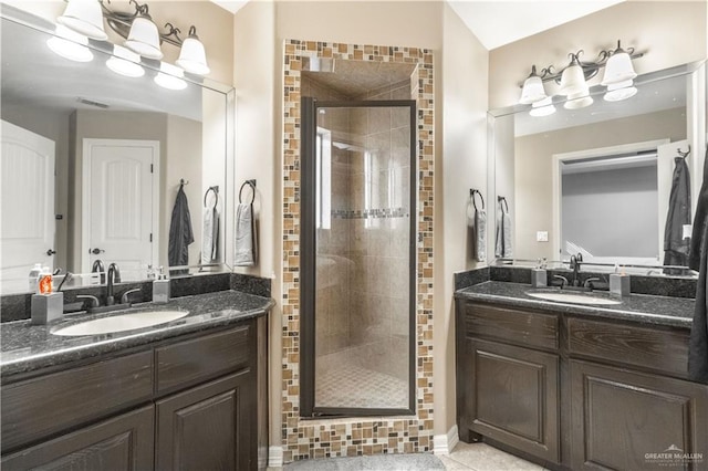 bathroom featuring two vanities, a sink, a stall shower, and tile patterned floors