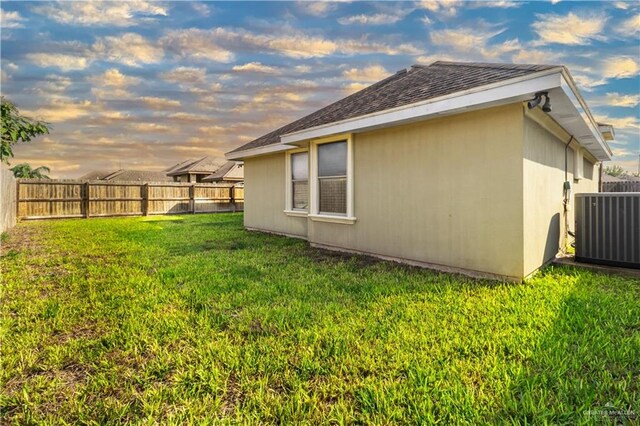 view of home's exterior featuring a fenced backyard, cooling unit, and a yard