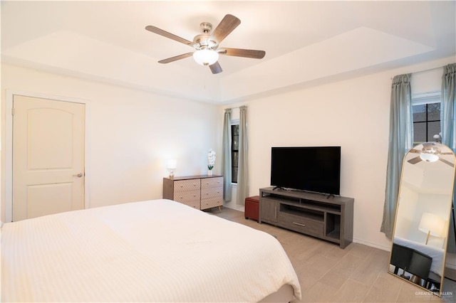 bedroom with a raised ceiling and ceiling fan