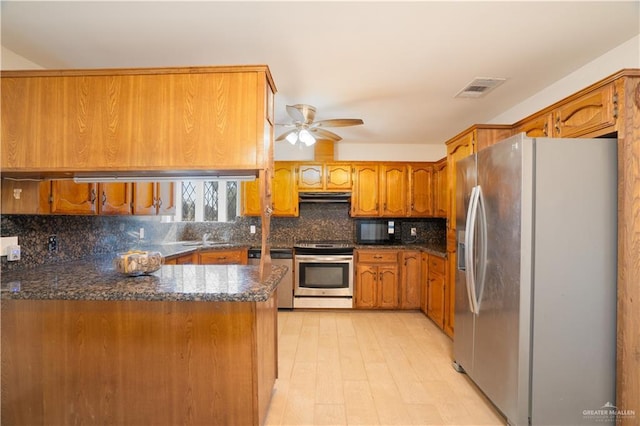 kitchen with kitchen peninsula, stainless steel appliances, decorative backsplash, ceiling fan, and sink