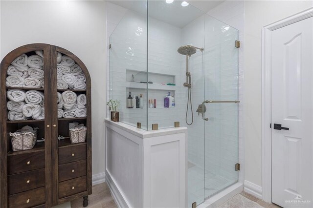 full bathroom featuring baseboards and a shower stall