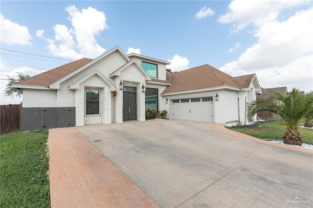 view of front of home featuring fence, stucco siding, an attached garage, and concrete driveway