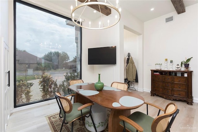 dining room with a notable chandelier, beamed ceiling, light wood finished floors, and visible vents