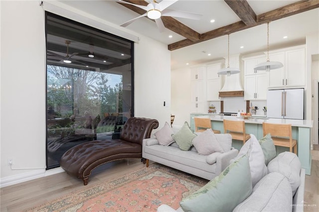 living area featuring a ceiling fan, beam ceiling, light wood-style floors, and baseboards