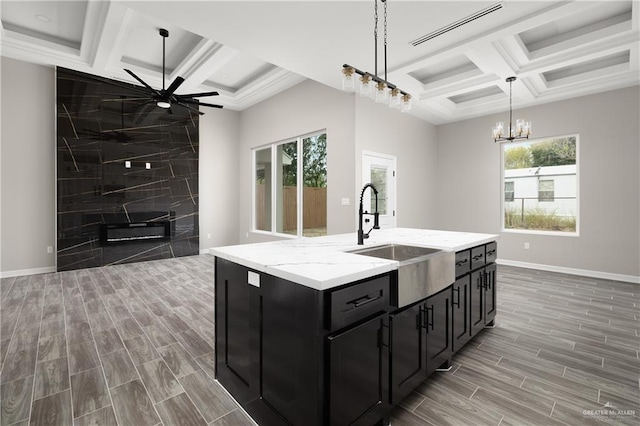 4911 Aguajito St, Edinburg, TX 78542 - kitchen featuring pendant lighting, coffered ceiling, sink, tile walls, and an island with sink