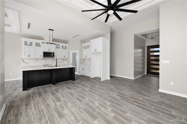 4911 Aguajito St, Edinburg, TX 78542 - kitchen featuring white cabinets, pendant lighting, light hardwood / wood-style floors, and tasteful backsplash