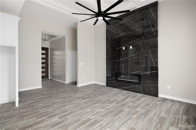 empty room featuring ceiling fan with notable chandelier and light wood-type flooring