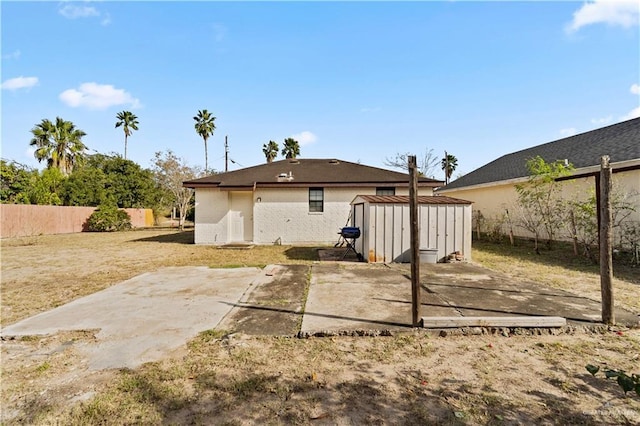 back of house featuring a storage unit and a patio