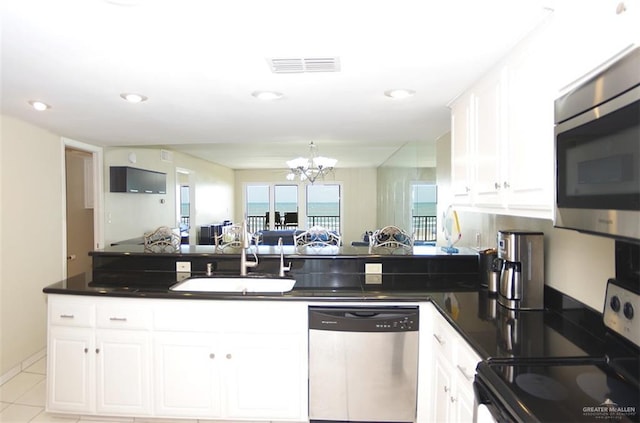 3400 Gulf Blvd Unit 403, South Padre Island, TX 78597 - kitchen with appliances with stainless steel finishes, dark countertops, a chandelier, white cabinetry, and open floor plan