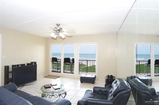 3400 Gulf Blvd Unit 403, South Padre Island, TX 78597 - living room featuring a water view, tile patterned floors, ceiling fan, and healthy amount of natural light