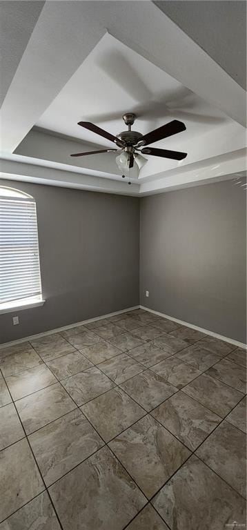 spare room featuring ceiling fan and tile patterned flooring