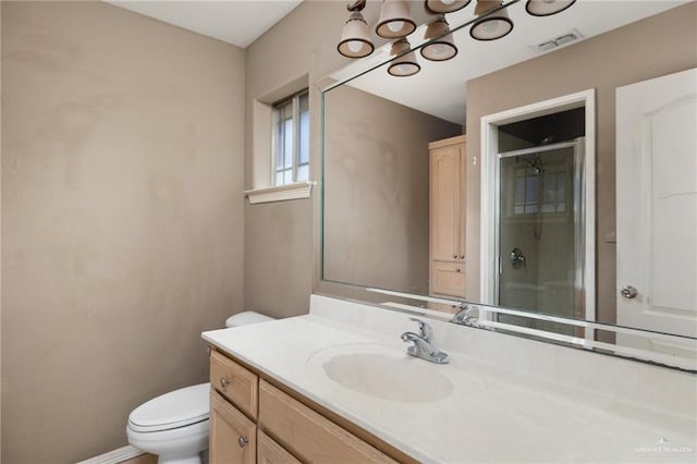 bathroom featuring walk in shower, vanity, and toilet