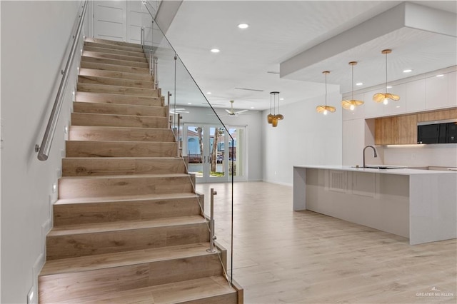 stairway with sink and wood-type flooring