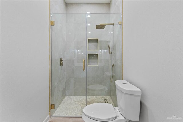 bathroom featuring an enclosed shower and toilet