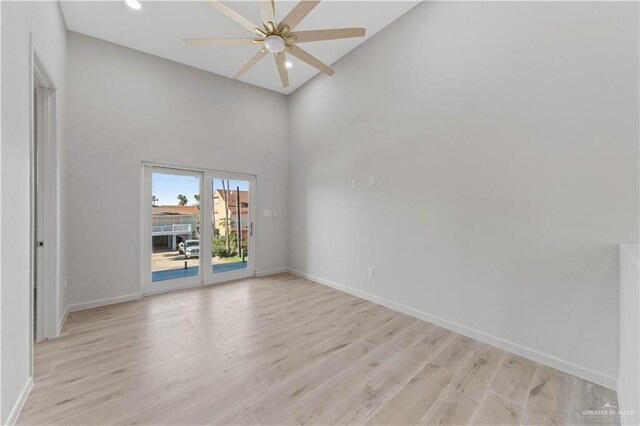 unfurnished room featuring ceiling fan, light wood-type flooring, and high vaulted ceiling