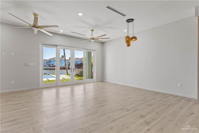 empty room with ceiling fan, french doors, and light hardwood / wood-style floors