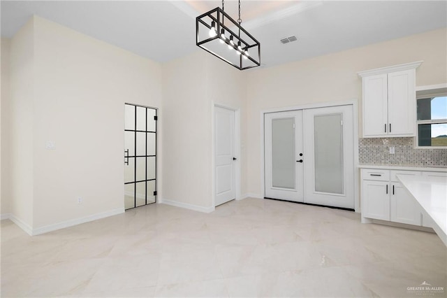 unfurnished dining area featuring french doors, visible vents, and baseboards