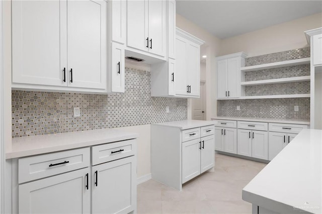 kitchen featuring light countertops, open shelves, backsplash, and white cabinets