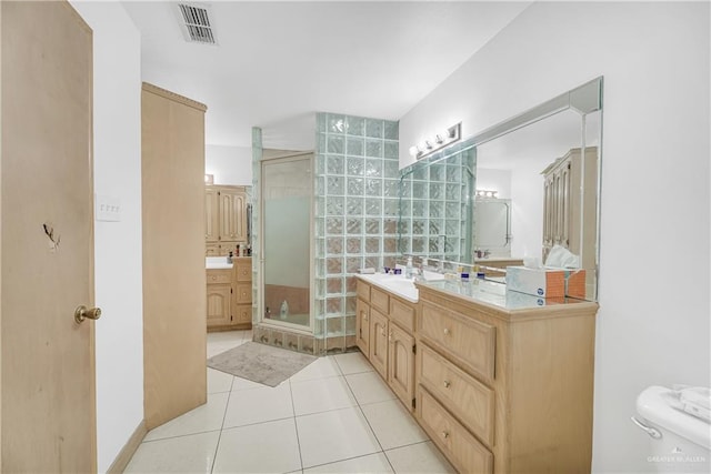 bathroom featuring tile patterned floors, vanity, and a shower with door