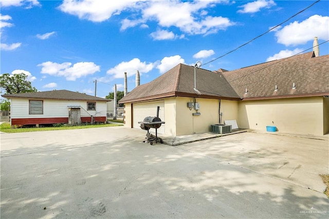 view of property exterior featuring a garage and central AC