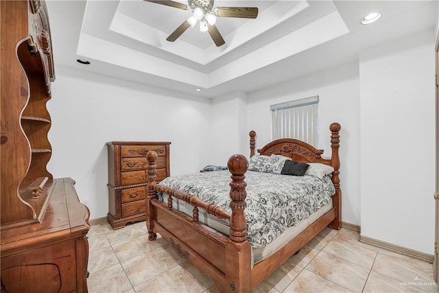 tiled bedroom featuring ceiling fan and a raised ceiling