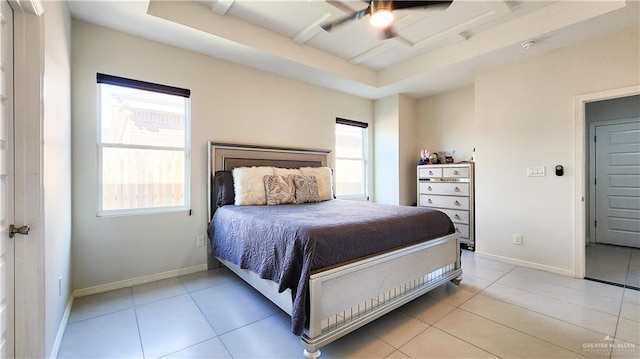 bedroom with multiple windows, baseboards, and a tray ceiling