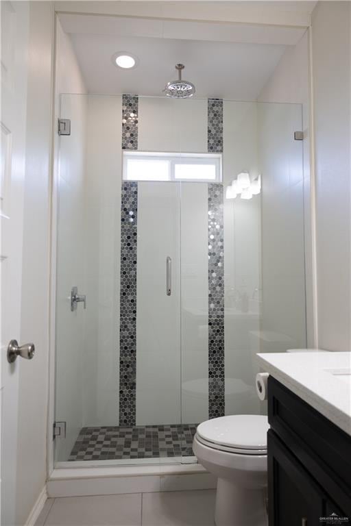 bathroom with vanity, toilet, and a shower stall