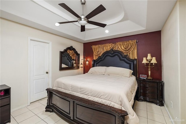 tiled bedroom featuring a raised ceiling and ceiling fan