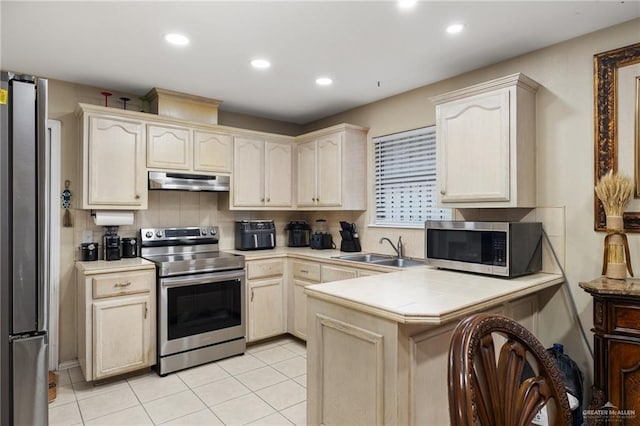 kitchen featuring light tile patterned flooring, sink, tasteful backsplash, kitchen peninsula, and stainless steel appliances