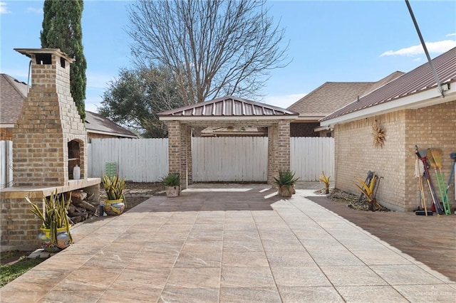 view of patio with a gazebo and a brick fireplace