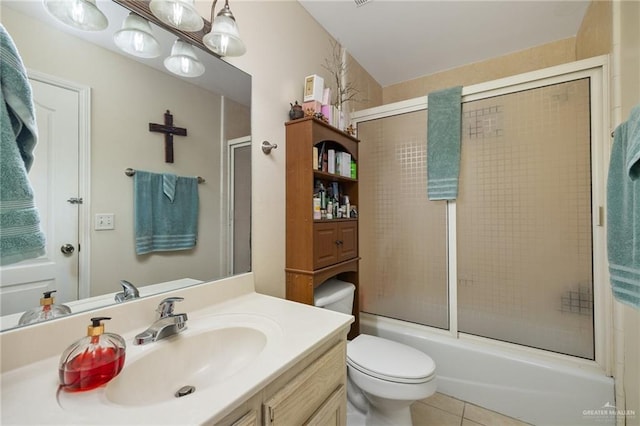 full bathroom featuring tile patterned floors, vanity, toilet, and enclosed tub / shower combo