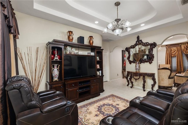 tiled living room featuring an inviting chandelier and a raised ceiling