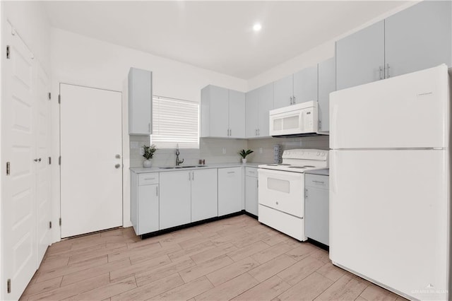 kitchen featuring light hardwood / wood-style floors, white appliances, sink, and tasteful backsplash