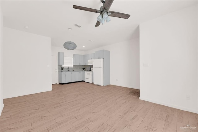 unfurnished living room with ceiling fan, light hardwood / wood-style floors, and sink