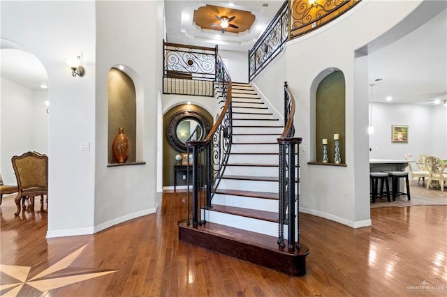 6614 Mile 7 Rd, Mission, TX 78573 - stairway featuring arched walkways, hardwood / wood-style floors, baseboards, ceiling fan, and a high ceiling
