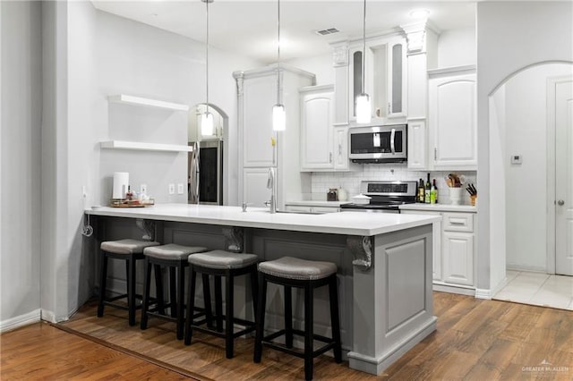 6614 Mile 7 Rd, Mission, TX 78573 - kitchen featuring stainless steel appliances, a sink, a kitchen bar, and backsplash