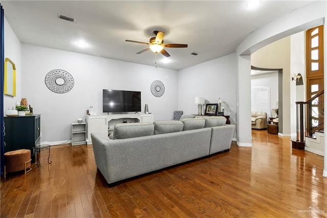 6614 Mile 7 Rd, Mission, TX 78573 - living room featuring ceiling fan, wood finished floors, stairway, arched walkways, and baseboards