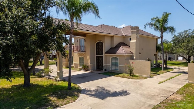 6614 Mile 7 Rd, Mission, TX 78573 - mediterranean / spanish-style home featuring concrete driveway, a balcony, stucco siding, a tiled roof, and a front lawn